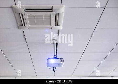 Un proiettore a soffitto bianco in una sala conferenze/classe moderna (immagine a colori) Foto Stock