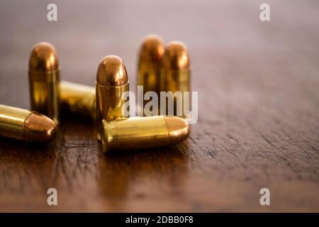 Pallottole d'oro su superficie di legno Foto Stock