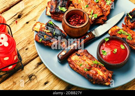 Costolette di manzo fritte con salsa di pomodoro su un vecchio tavolo di legno Foto Stock