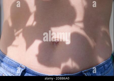 Ombra di foglie sul corpo della donna Foto Stock
