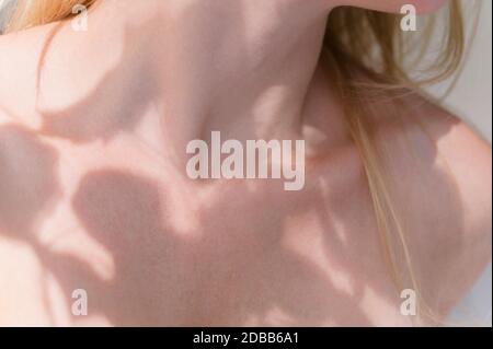 Ombra di foglie sul corpo della donna Foto Stock