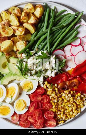 Verdure colorate, insalata e uova sul piatto Foto Stock