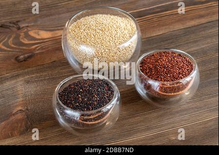 Diversi tipi di quinoa su sfondo di legno Foto Stock