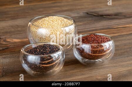 Diversi tipi di quinoa su sfondo di legno Foto Stock