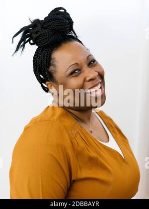 Ritratto di donna sorridente con capelli neri intrecciati Foto Stock