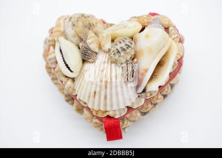 Scatola orafa a forma di cuore fatta a mano con conchiglie su sfondo bianco Foto Stock