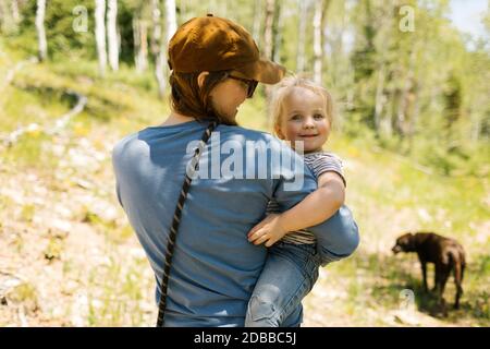 Vista posteriore della donna che porta la figlia (2-3) in paesaggio Foto Stock