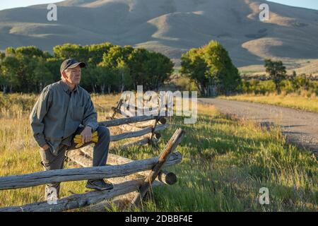 USA, Idaho, Bellevue, contadino che pende contro la recinzione sul campo Foto Stock