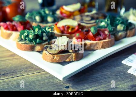 Bruschetta con fagioli e rucola, funghi, formaggi di capra. Foto Stock