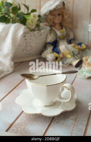 Elegante tazza da tè bianca su tavolo shabby, verticale Foto Stock