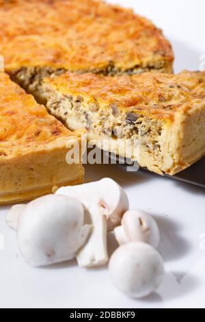 Torta di funghi a fette con funghi in primo piano. Su una tavola bianca. Messa a fuoco selettiva. Foto Stock