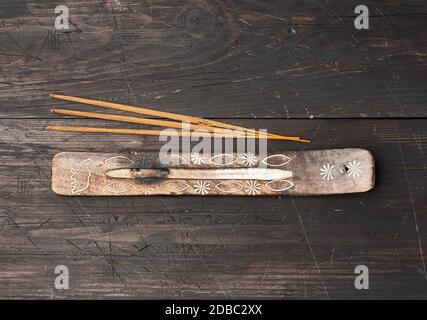 pila di bastoncini di incenso per rituali e un piedistallo su un tavolo di legno marrone, vista dall'alto Foto Stock