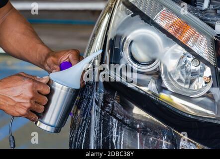 Dopo aver lucidato la luce anteriore della vettura. Rivestito con vernice per fari. Foto Stock