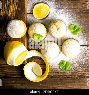 Muffin con limone e menta su un tagliere su un tavolo di legno scuro. Viste dall'alto, primo piano. Foto Stock