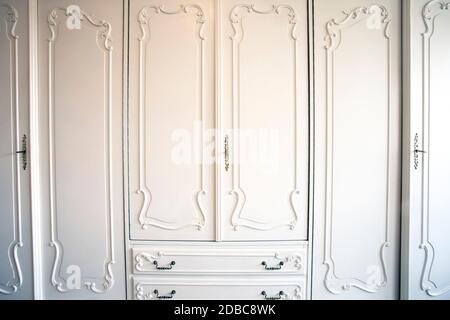 Porte bianche per armadio con chiave dorata in toppa, lusso antico design primo piano porte vintage in legno bellezza Foto Stock