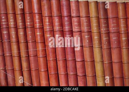 Vintage di libri in diverse sfumature di rosso e marrone in libreria Foto Stock