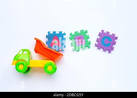 Giocattoli colorati per bambini con puzzle in alfabeto inglese su sfondo bianco. Concetto di formazione, spazio di copia Foto Stock