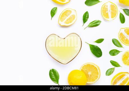 Forma di cuore bicchiere di spremuta di limone con il succo di limone fresco su sfondo bianco. Spazio di copia Foto Stock