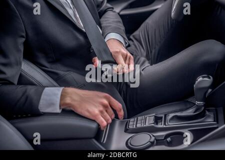 Primo piano della cintura di sicurezza allacciata alle mani del conducente Foto Stock