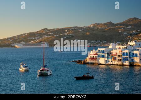 Tramonto sull'isola di Mykonos, Grecia, con yacht nel porto e colorate case sul lungomare di Little Venice, luogo romantico al tramonto e nave da crociera. Il mio Foto Stock