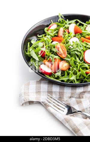 Insalata di rucola fresca con ravanelli, pomodori e peperoni rossi sul piatto. Foto Stock