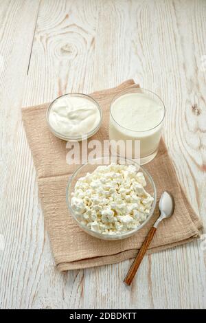 Formaggio fresco di cottage villaggio e panna acida in ciotola di vetro e bicchiere con yogurt. Cibo sano. Prodotto dietetico. Latticini. Foto Stock