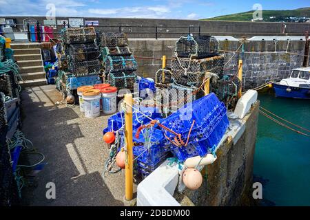 Pentole di aragosta e altre attrezzature da pesca immagazzinate sul molo a Port Erin, Isola di Man Foto Stock