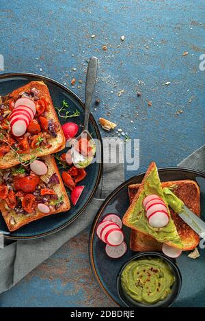 Hummus colorato, diverse salse, spuntino vegano, fette di pomodoro e hummus avocado, cibo vegetariano Foto Stock