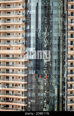 Equipaggio di manutenzione è la pulizia di vetri di un grattacielo a Dubai, Emirati arabi uniti Foto Stock