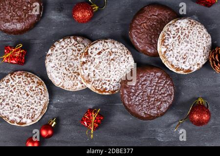 Biscotti rotondi di pan di zenzero tedeschi chiamati 'Lebkuchen' con bianco e cioccolato Vetri circondati da decorazioni natalizie stagionali Foto Stock