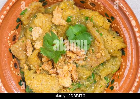 Scorza di maiale in salsa verde, Chicharron in salsa verde, cibo messicano. Una colazione tradizionale e popolare in Messico, servita con croccanti croccanti di maiale e b Foto Stock