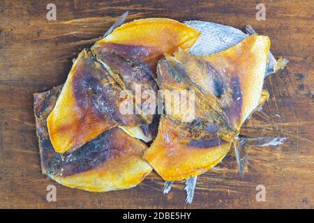 Orata secca in forma di farfalla su sfondo di legno. Snack Pesce alla birra. Primo piano. Foto Stock