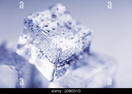 Ghiaccio con gocce di acqua di fusione da vicino su sfondo bianco. Cubo di ghiaccio Foto Stock