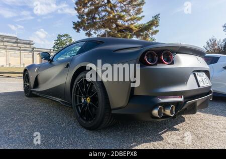 Posteriore 3/4 vista di una Ferrari 812 Superfast nero opaco con cerchi da corsa neri forgiati da 20 pollici all'aperto sotto il sole Foto Stock