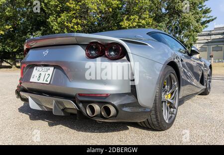 Vista posteriore 3/4 di una Ferrari 812 Superfast argento all'aperto sotto il sole, che mostra le luci di lettura e diffusore colorato Foto Stock