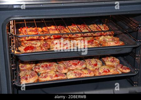 Deliziosi panini caldi sono cucinati in forno su badge. Panini caldi con salsiccia e formaggio fuso cucinando nel piatto del nome. Cucina gustosa piatto. Homemad Foto Stock