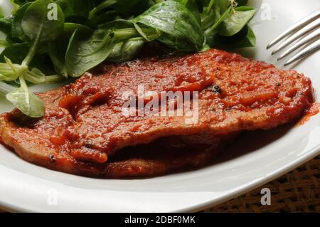 Filetto di maiale con salsa di pomodoro e insalata di mais Foto Stock