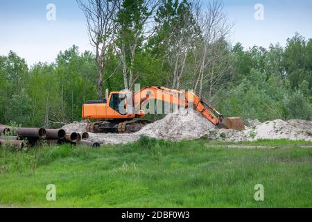 Escavatore sul cantiere che costruisce la pipeline Foto Stock