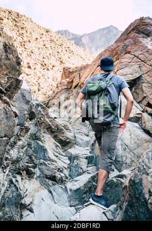 Un uomo è escursioni attraverso un wadi in montagne Hajar vicino Hatta Emirati arabi uniti Foto Stock