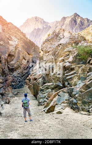 Un uomo è escursioni attraverso un wadi in montagne Hajar vicino Hatta Emirati arabi uniti Foto Stock