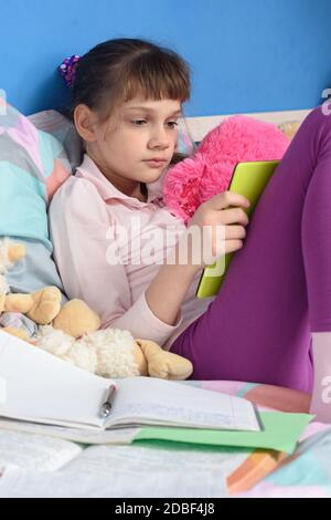 La ragazza a letto impara a distanza a casa Foto Stock