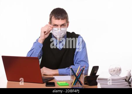 L'impiegato in una maschera medica abbassò i suoi occhiali da occhio a naso Foto Stock