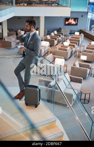 Ufficiale commerciale che porta una tazza in bocca Foto Stock