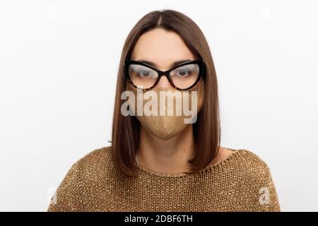 Primo piano tenero di bella donna brunetta che ha problemi con l'appannamento occhiali dovuti all'uso di una maschera medica Foto Stock