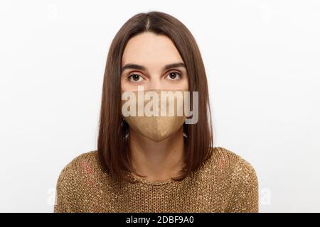 Donna che indossa abiti alla moda durante la quarantena del coronavirus focolaio. Aspetto totale con maschera protettiva elegante fatta a mano Foto Stock