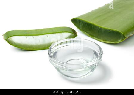 Foglia verde di aloe vera, fetta e una ciotola di vetro con gel su sfondo bianco primo piano Foto Stock