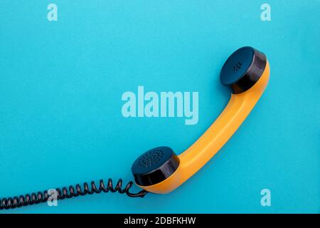 Telefono arancione retro vintage su blu Foto Stock