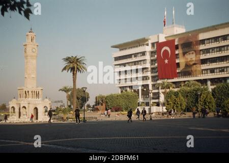 Izmir, Turchia - 16 novembre 2020 Film scan con qualche granello della Torre dell'Orologio di Konak con alcune persone con bandiera turca e poster Ataturk. Foto Stock