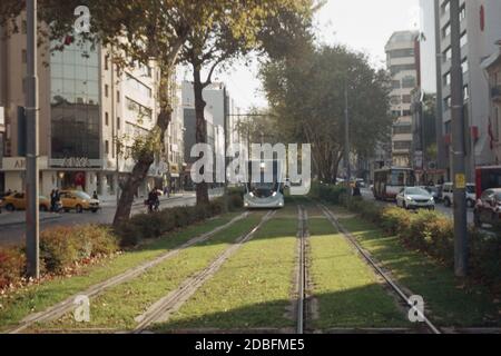 Izmir, Turchia - 16 novembre 2020. Vista su tram, ferrovia e Cankaya. Fotografato con una fotocamera e una scansione di film. Immagine sfocata e granulare. Foto Stock