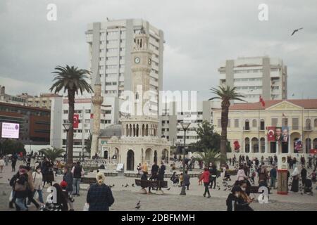 Izmir, Turchia - 16 novembre 2020 Film scan con qualche granello della Torre dell'Orologio di Konak con alcune persone con bandiera turca e poster Ataturk. Foto Stock